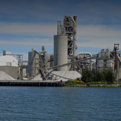 Cement plant with preheater tower and silos on a waterfront